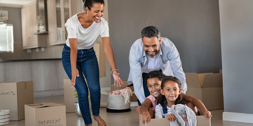 young family playing in moving boxes